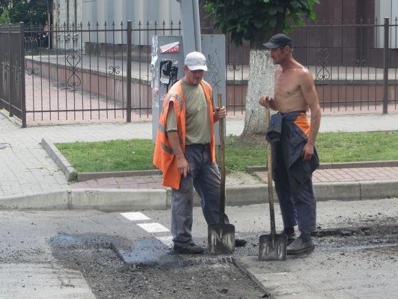Фото дня: рух на Володимирській перекрили. Комунальники латають ями, фото №3 на сайті vsim.ua