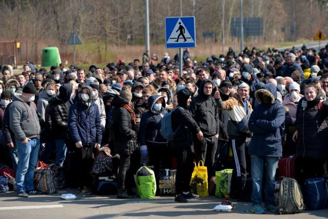 «Радію, що я не там!» В масках і натовпом заробітчани переходять пішки кордон з Польщею