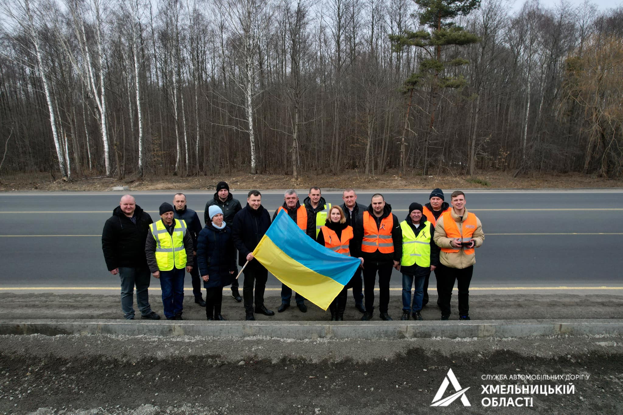 Новини Хмельницького - фото з До Дня єднання хмельницькі дорожники влаштували автопробіг (ФОТО, ВІДЕО) На зображенні може бути: 9 людей, люди стоять та дорога