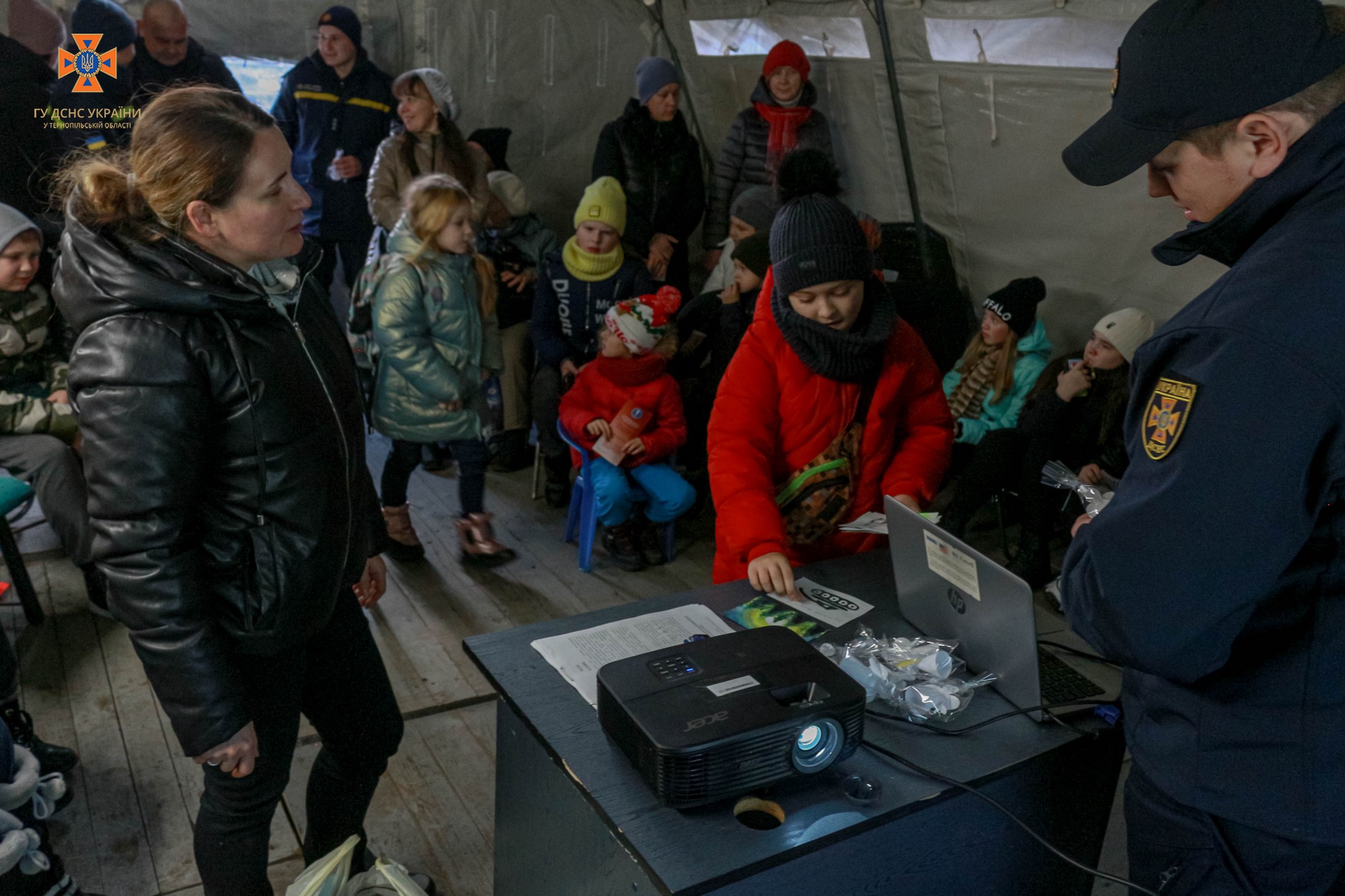 Новини Тернополя - фото з Тернопільські рятувальники провели «Урок безпеки» для малечі у «Пункті незламності»: дивіться фото На зображенні може бути: 12 людей, люди сидять та люди стоять