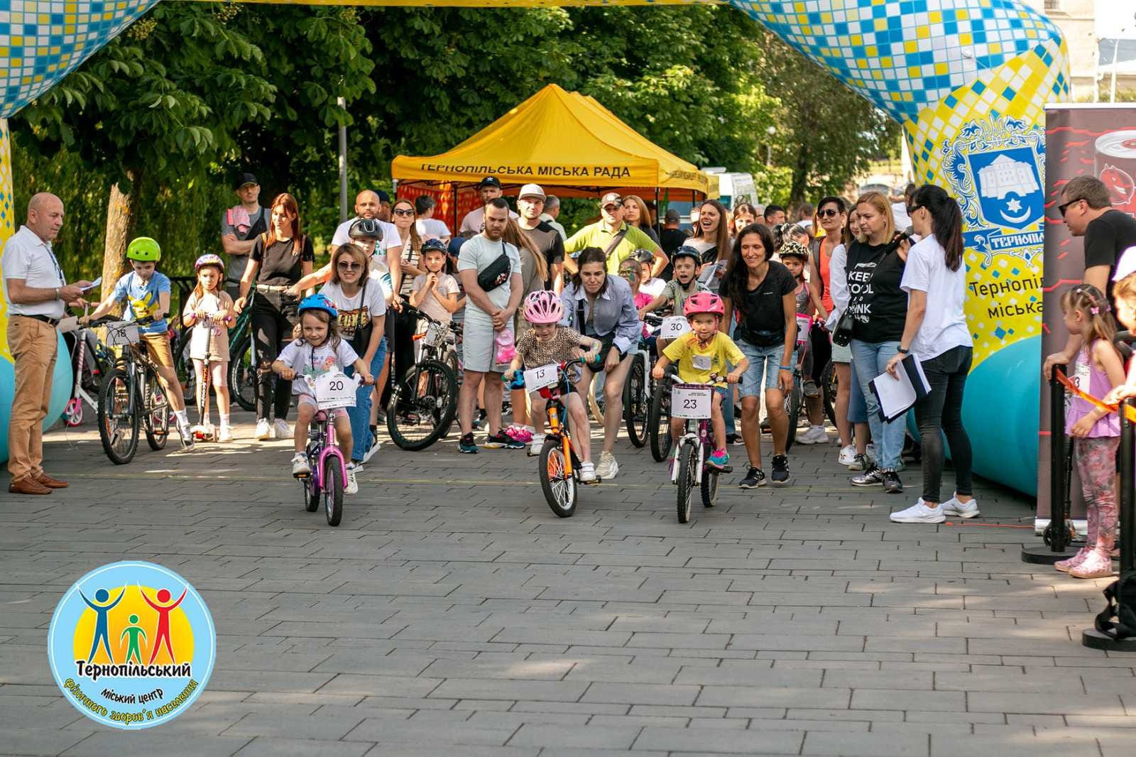 На зображенні може бути: 11 людей, дитина, велосипед, скутер, сеґвей, натовп та текст