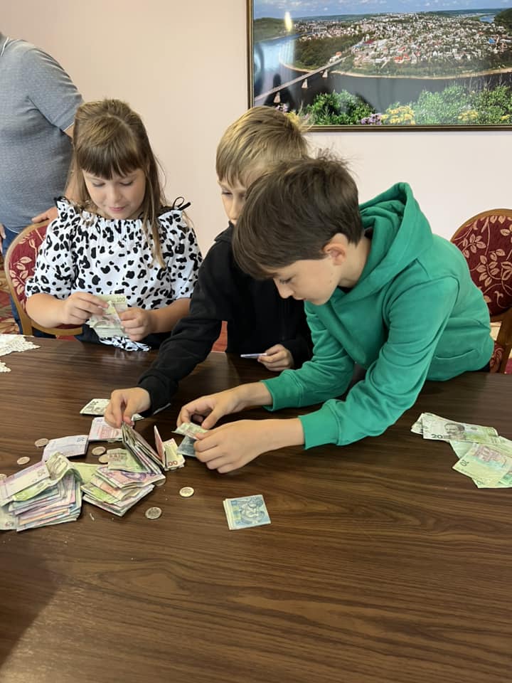 Новини Тернополя - фото з Зупиняли автівки та збирали кошти на Mavic: у Заліщиках діти організували блокпост для ЗСУ На зображенні може бути: 3 людини та стіл