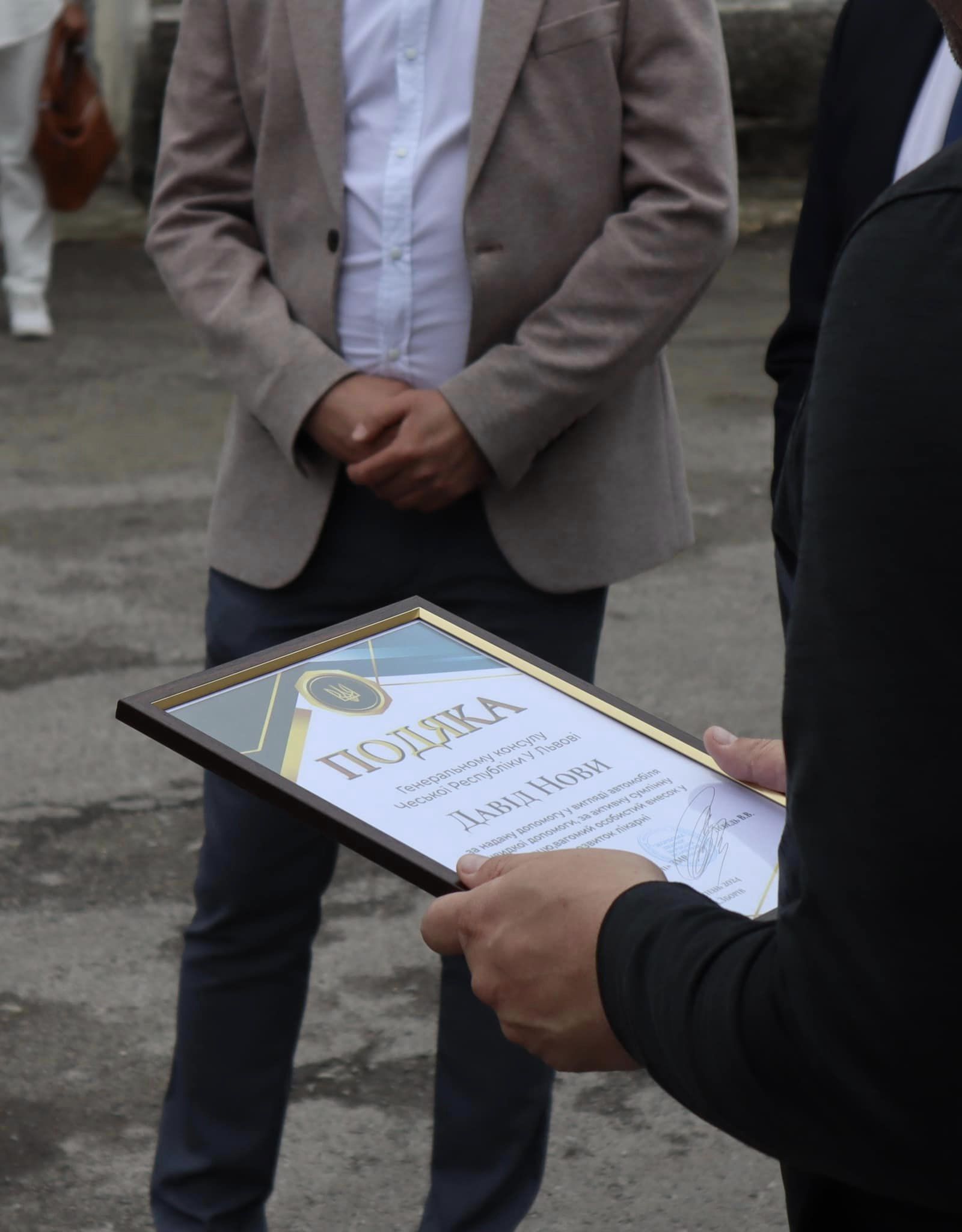 Новини Тернополя - фото з Збаразька лікарня отримала нову карету швидкої допомоги від благодійників з Чехії На зображенні може бути: 2 людини, костюм та текст