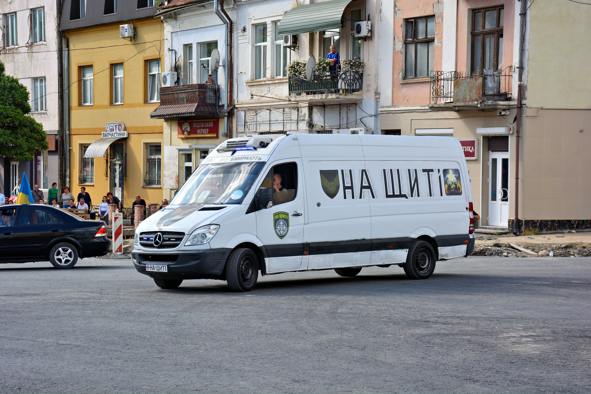На зображенні може бути: 7 людей, фургон, вулиця та текст