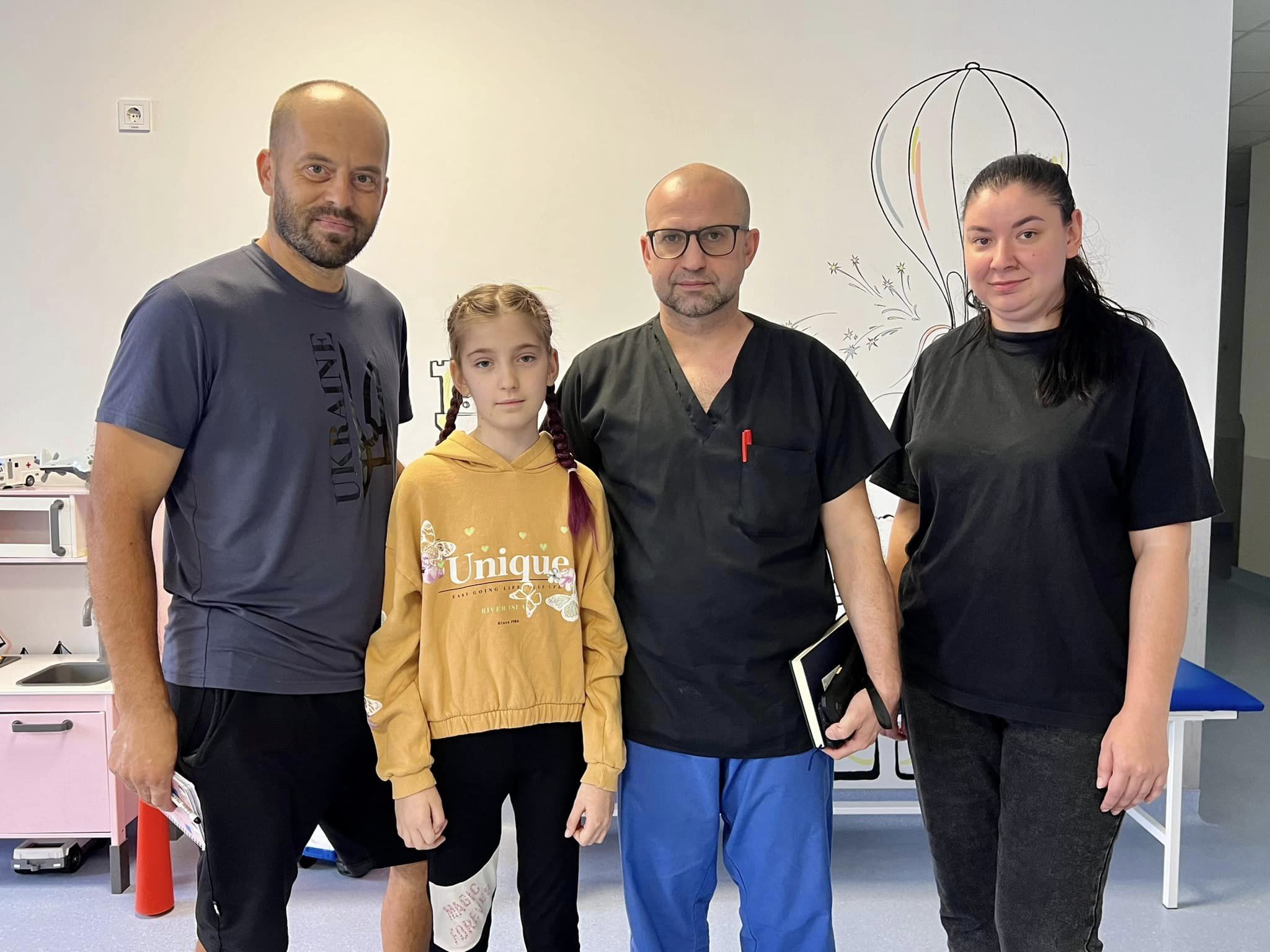 На зображенні може бути: 4 людини, люди усміхаються, лікарня та текст