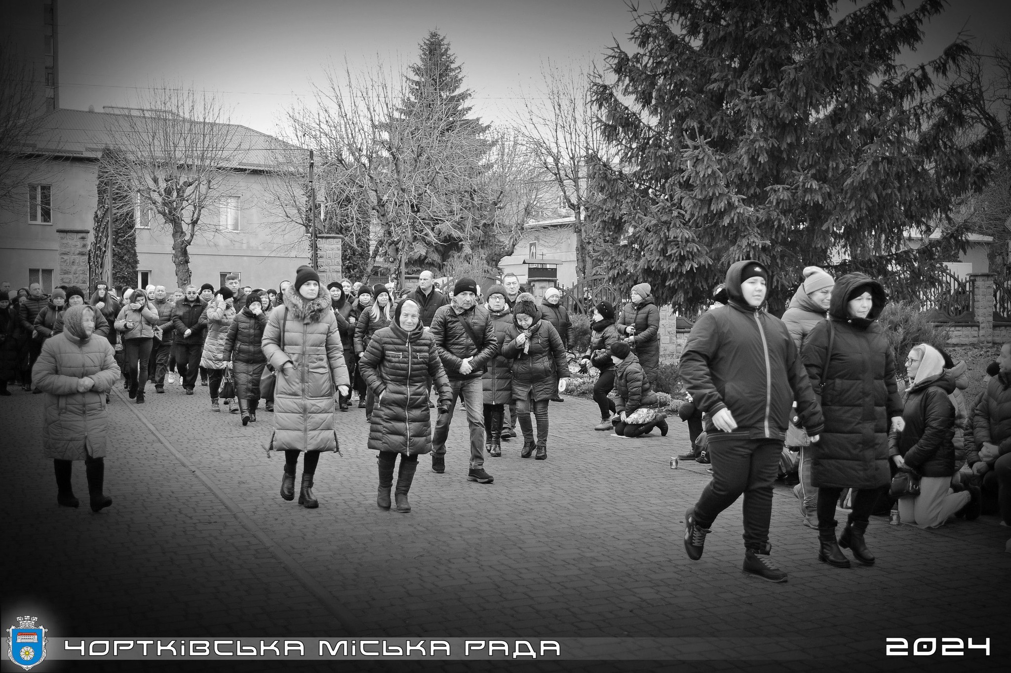 Можливо, це чорно-біле зображення 4 людини, натовп, вулиця та текст