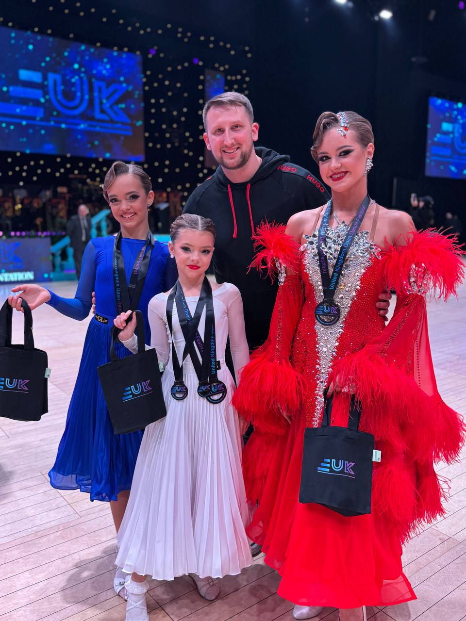 Новини Тернополя - фото з Чортківські танцюристи привезли перемоги з чемпіонату в  Британії На зображенні може бути: 3 людини та текст «UK UGO A0 GLS UK 三UK»